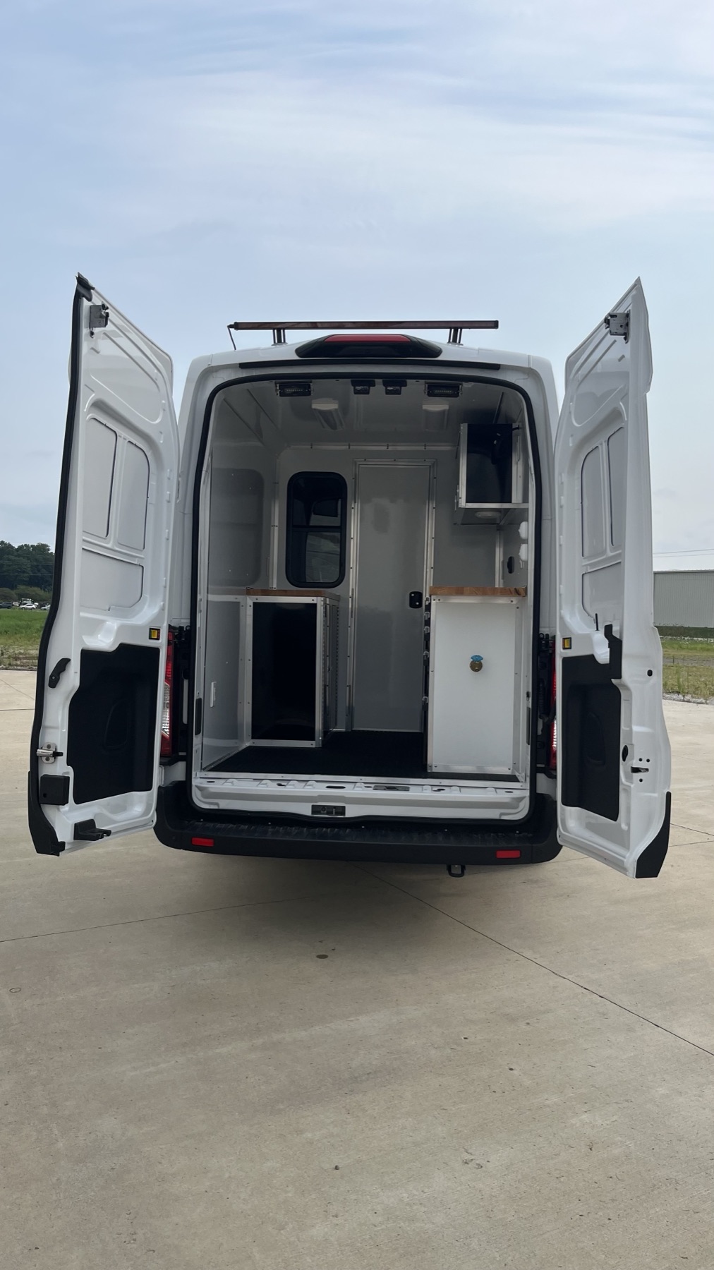 Rear cargo area with custom shelving units and diamond-plate flooring