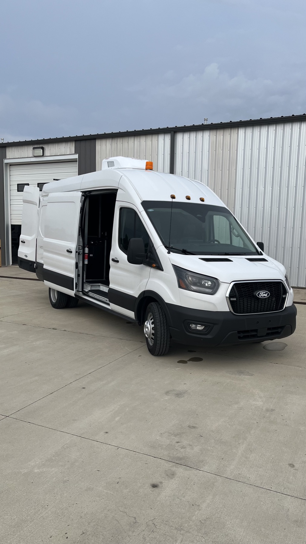 White Ford Transit cargo van with rear service doors open, converted by V Tech Conversions